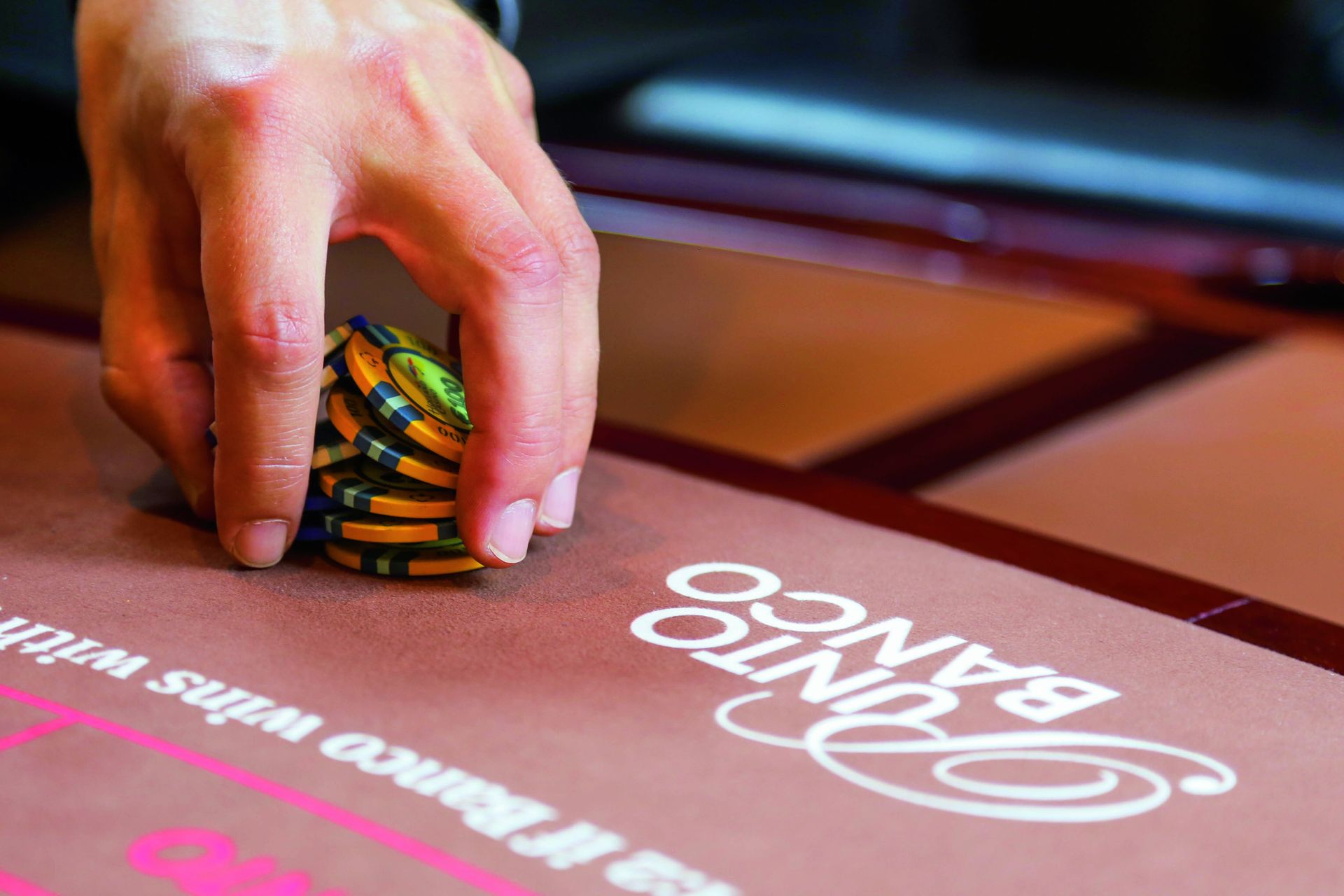 Hand met chips van Punto Banco-speler