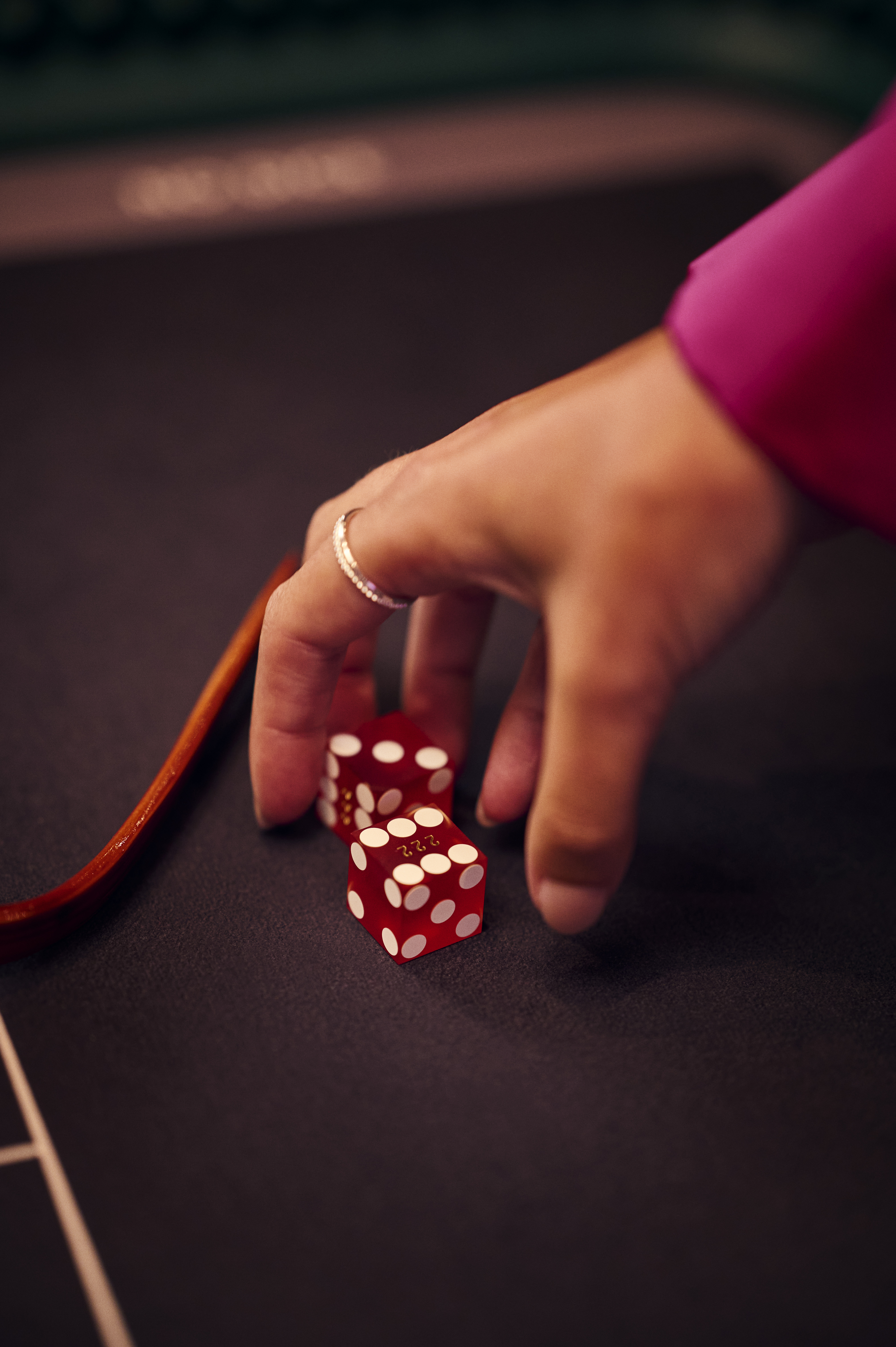 holland-casino-diceball-closeup-van-hand-met-twee-rode-dobbelstenen-op-tafel