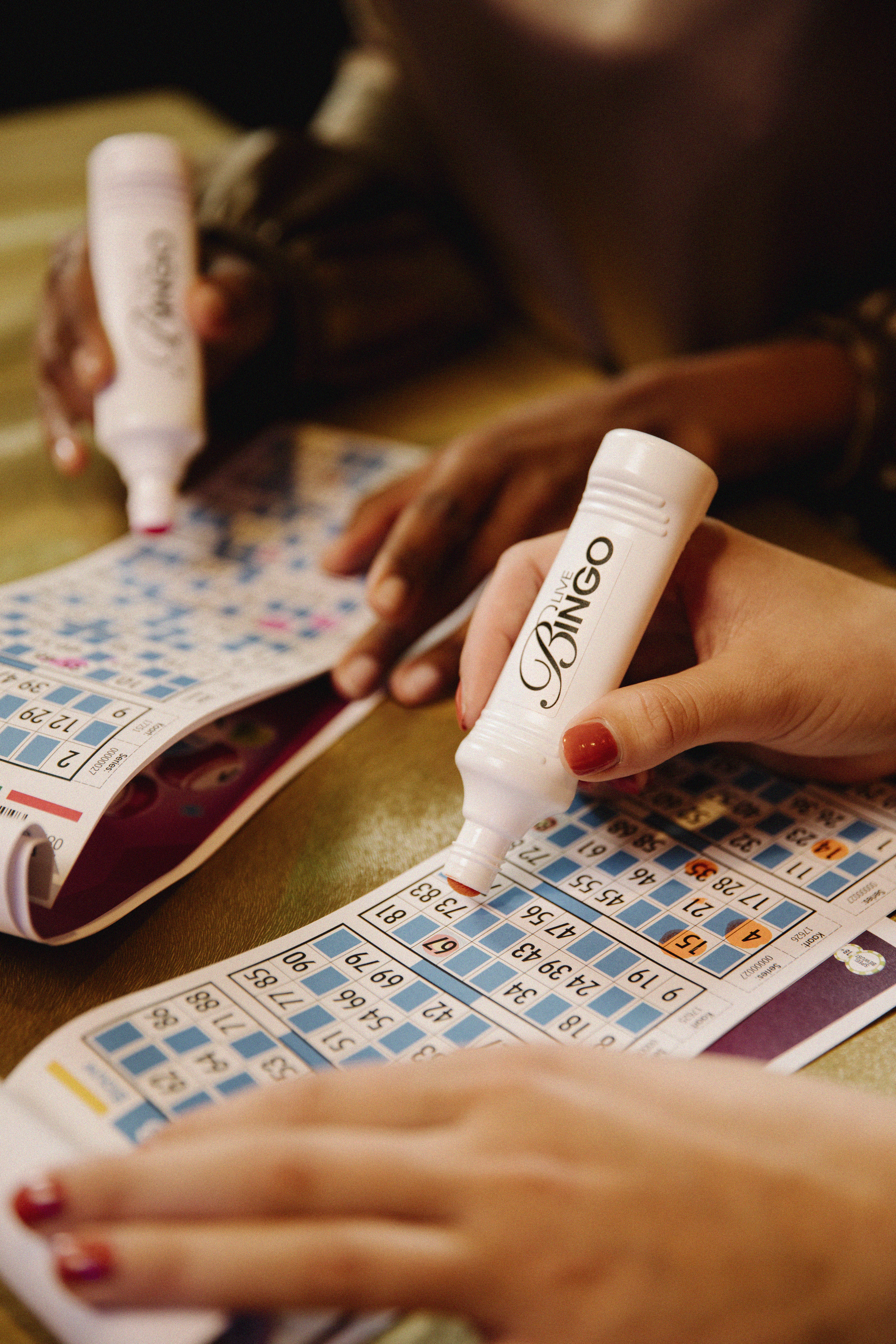 holland-casino-closeup-van-handen-van-twee-gasten-met-bingo-kaart