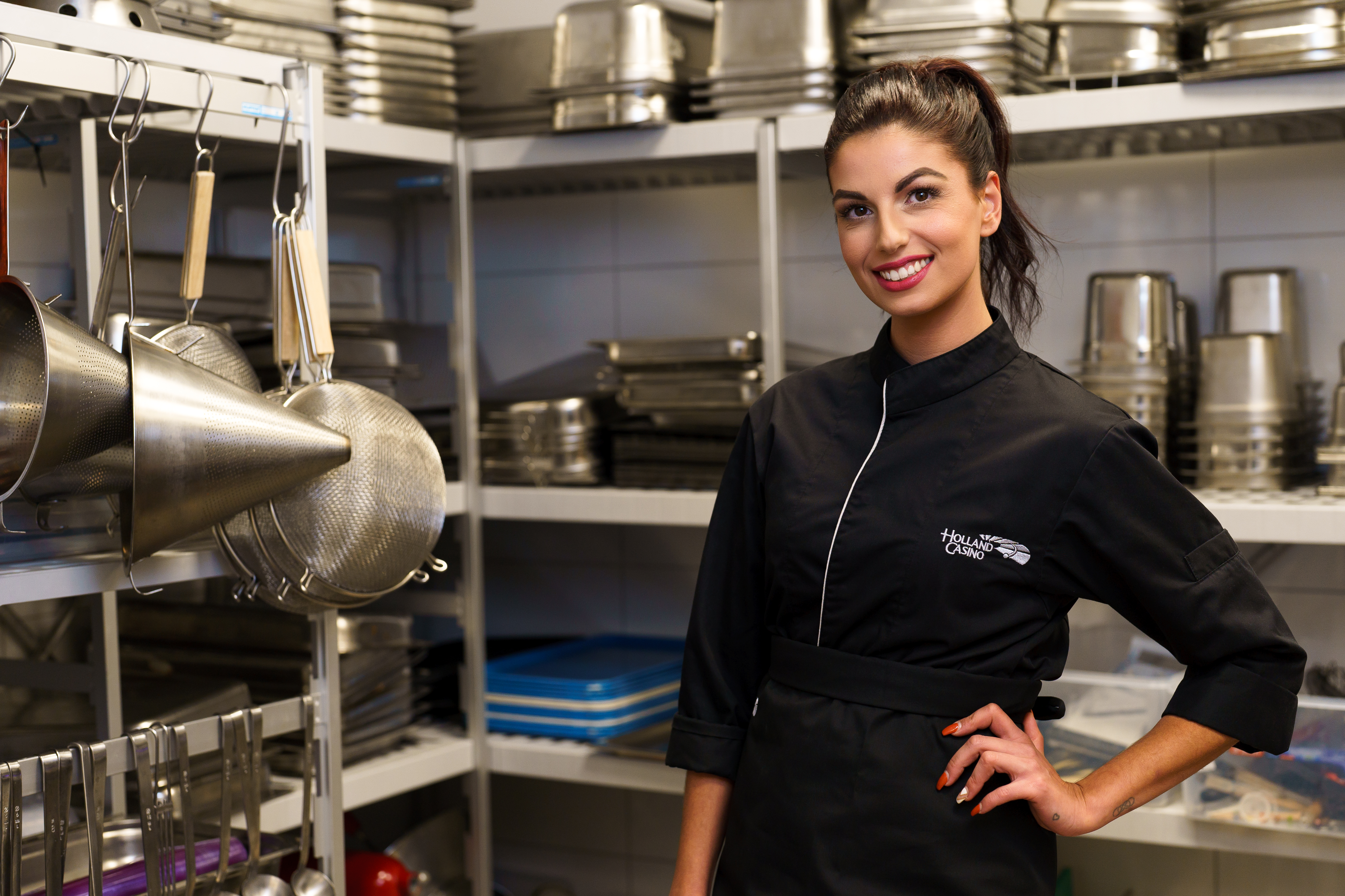 holland-casino-restaurant-kokkin-in-de-keuken-voor-rek-met-pannen