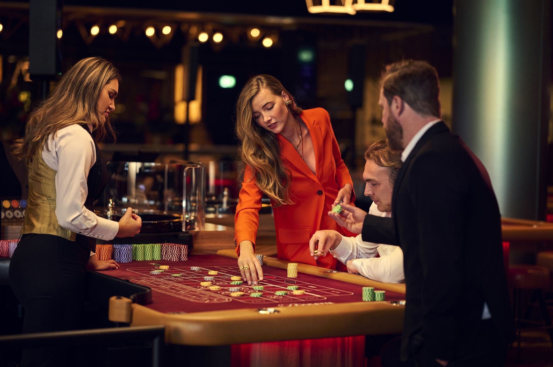 holland-casino-roulette-vrouw-die-inzet-op-speeltafel-met-coupier-en-andere-gasten