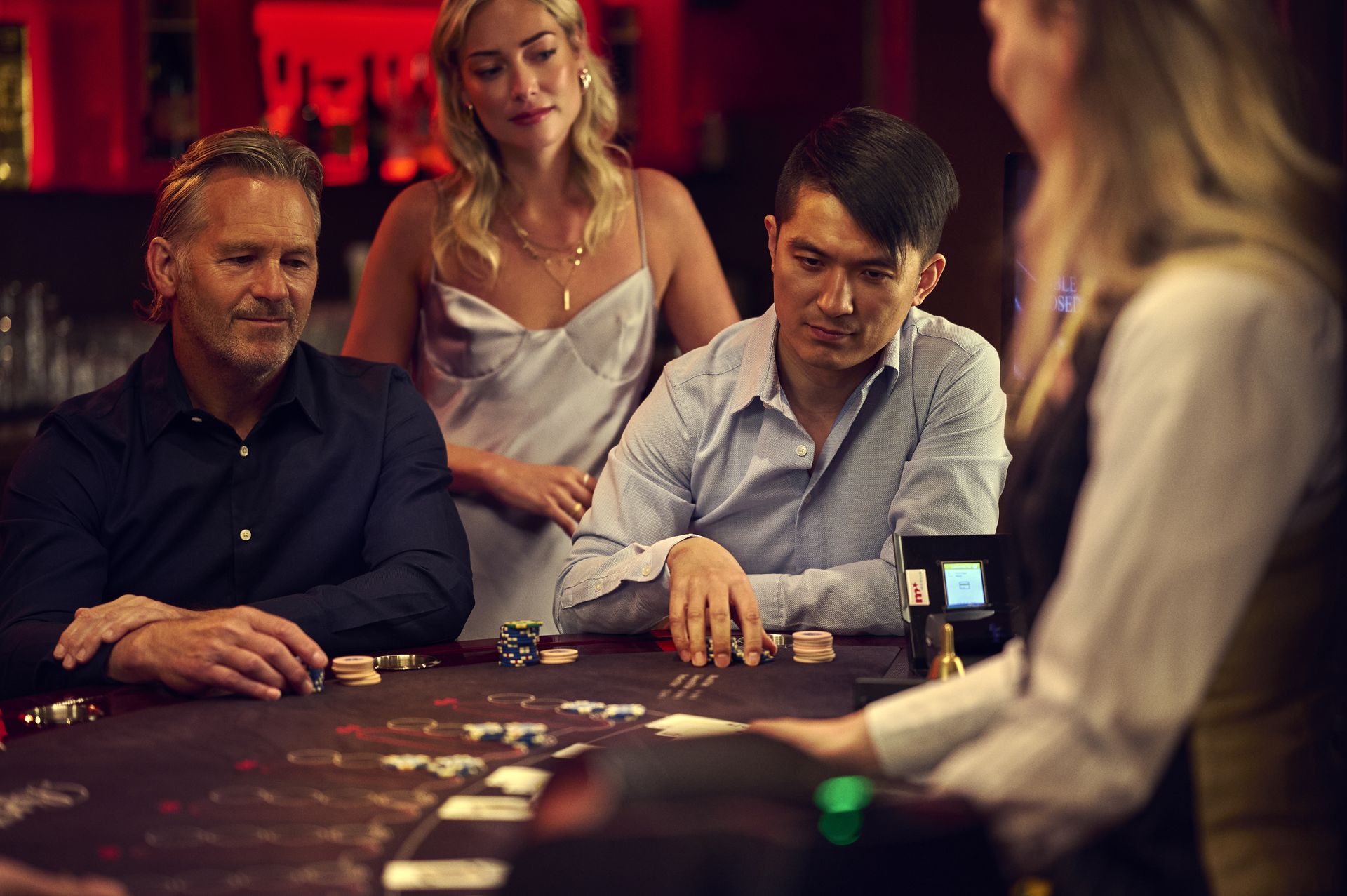 holland-casino-blackjack-drie-gasten-aan-speeltafel-met-toeschouwer-en-croupier