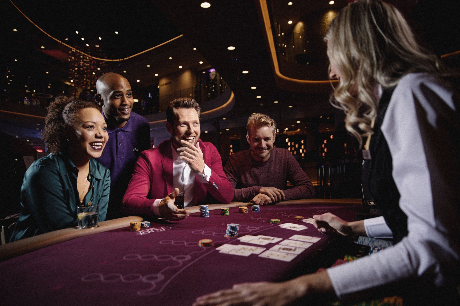 holland-casino-blackjack-drie-gasten-aan-speeltafel-met-toeschouwer-en-croupier