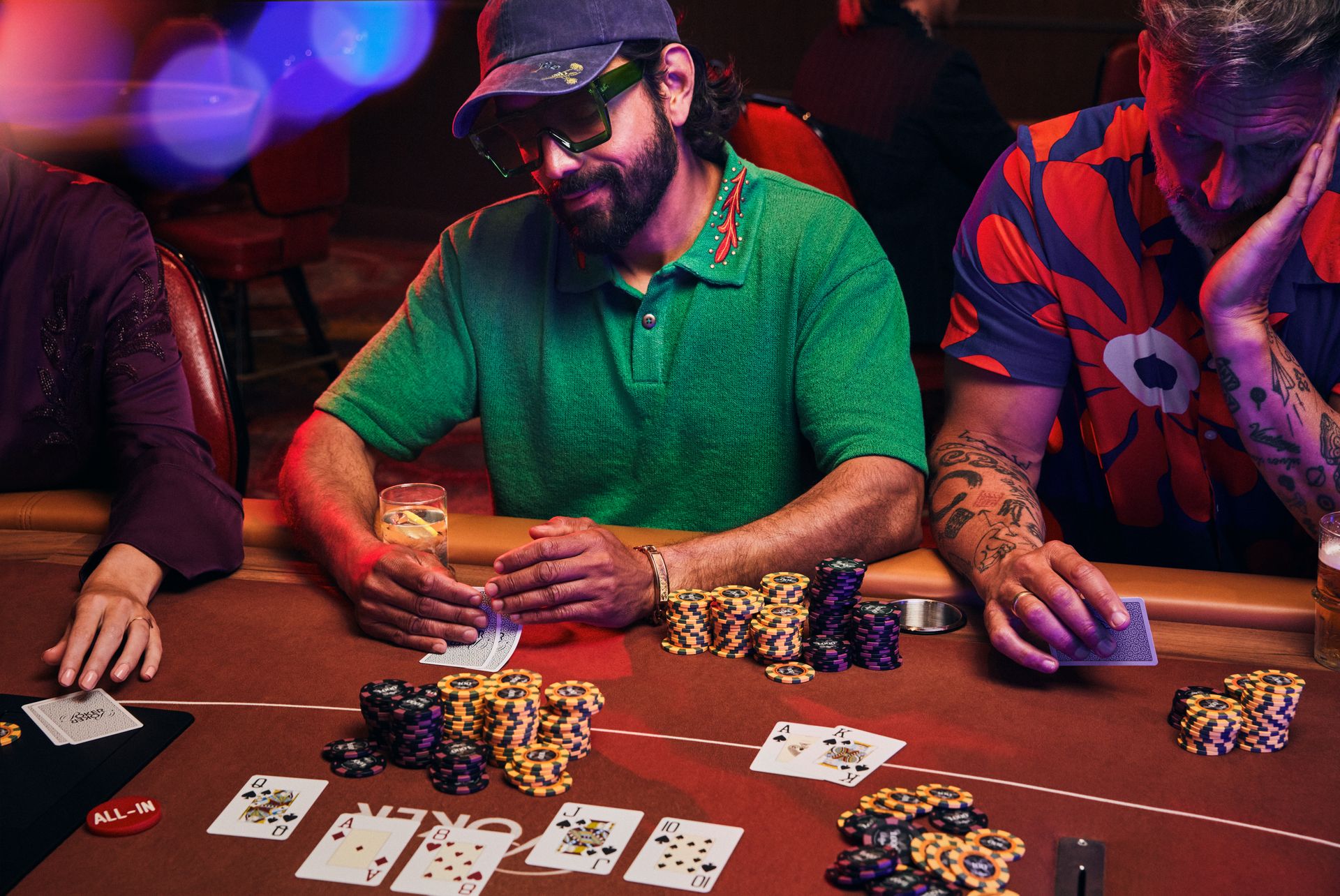 holland-casino-poker-tafel-met-drie-gasten-op-live-poker-toernooi--waarvan-middelste-gast-kaarten-bekijkt