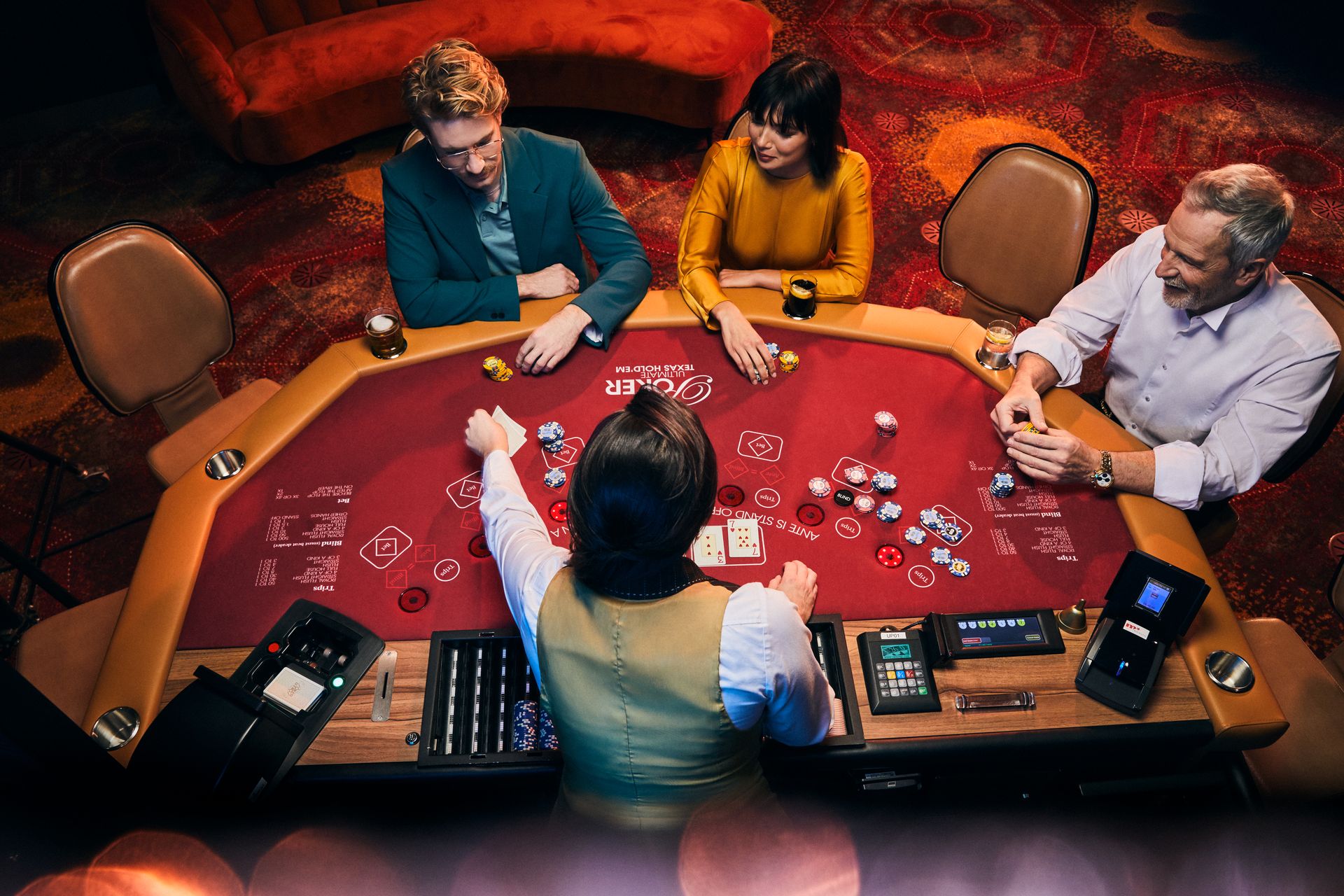holland-casino-poker-drie-gasten-aan-ultimate-texas-hold'em-poker-tafel-met-vrouwelijke-croupier-die-kaarten-uitdeelt